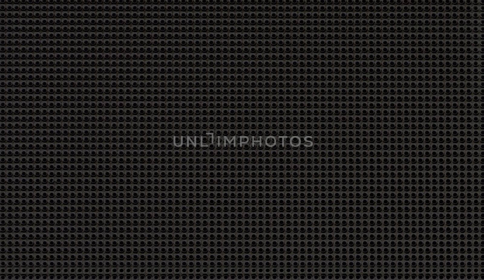 Spot lit perforated metal plate. Metal background close-up