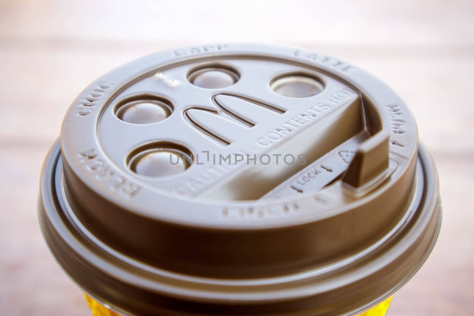 Plastic brown or black disposable top coffee lid with McDonald's fast food restaurant logo close up. Disposable coffee cup. Takeaway beverage cup. Ukraine, Kiev - September 13, 2021
