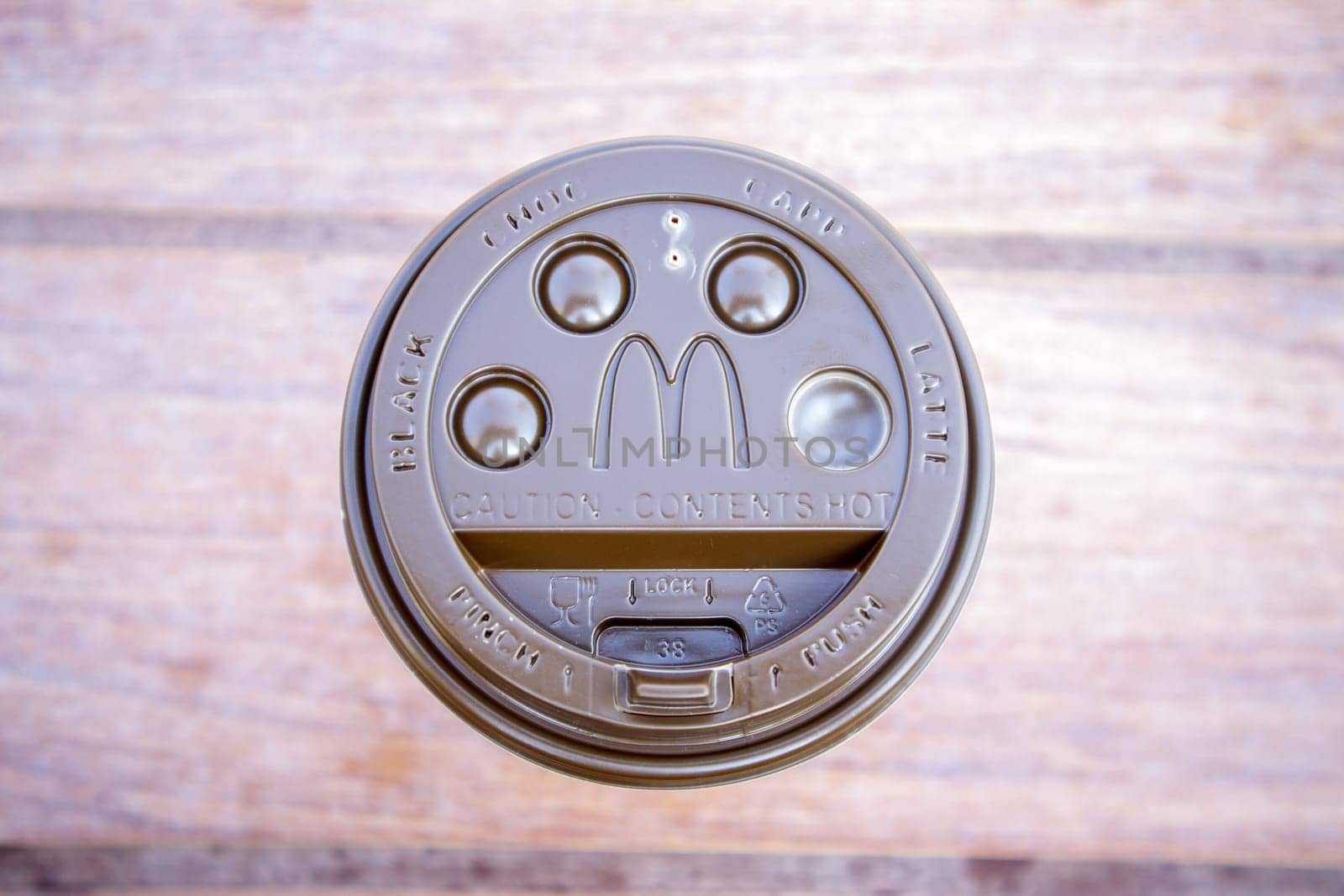 Plastic brown or black disposable top coffee lid with McDonald's fast food restaurant logo close up. Disposable coffee cup. Takeaway beverage cup. View from above. Ukraine, Kiev - September 13, 2021