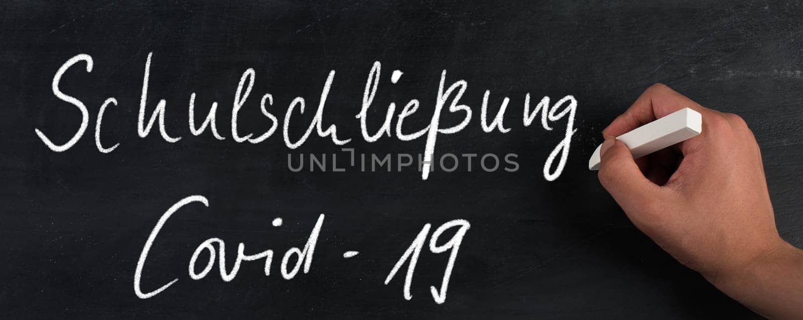School closed because of Covid-19 is standing in german language on a chalkboard