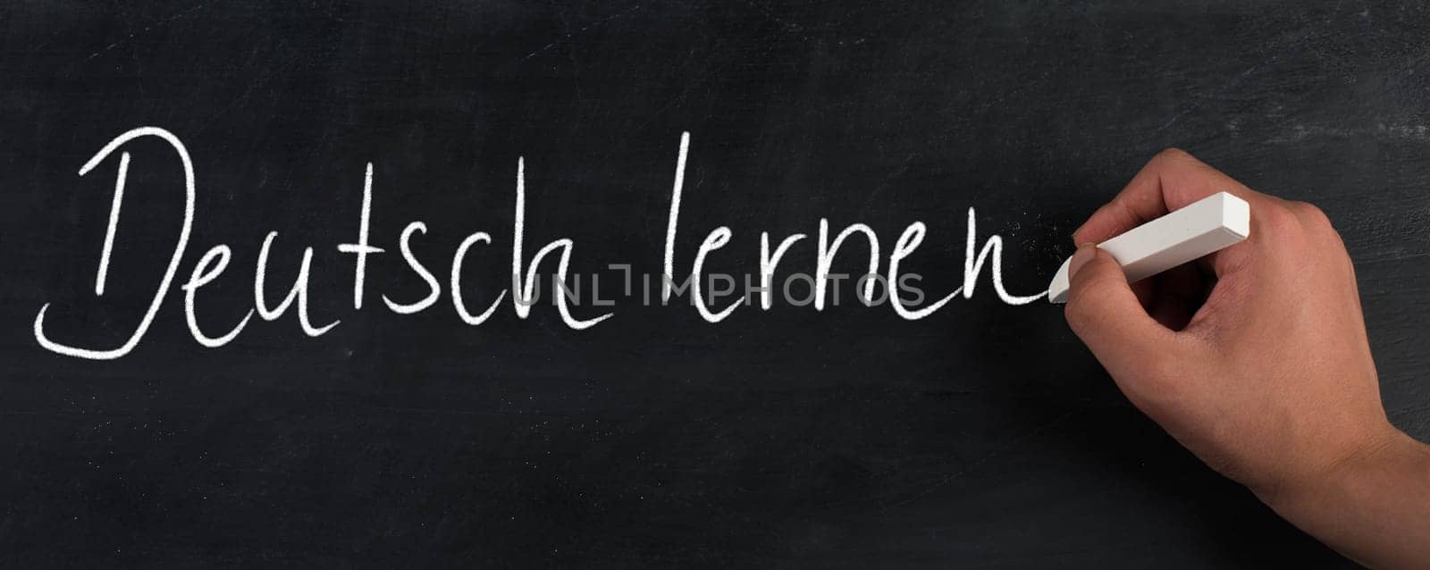 The words learn german are standing in the german language on a blackboard