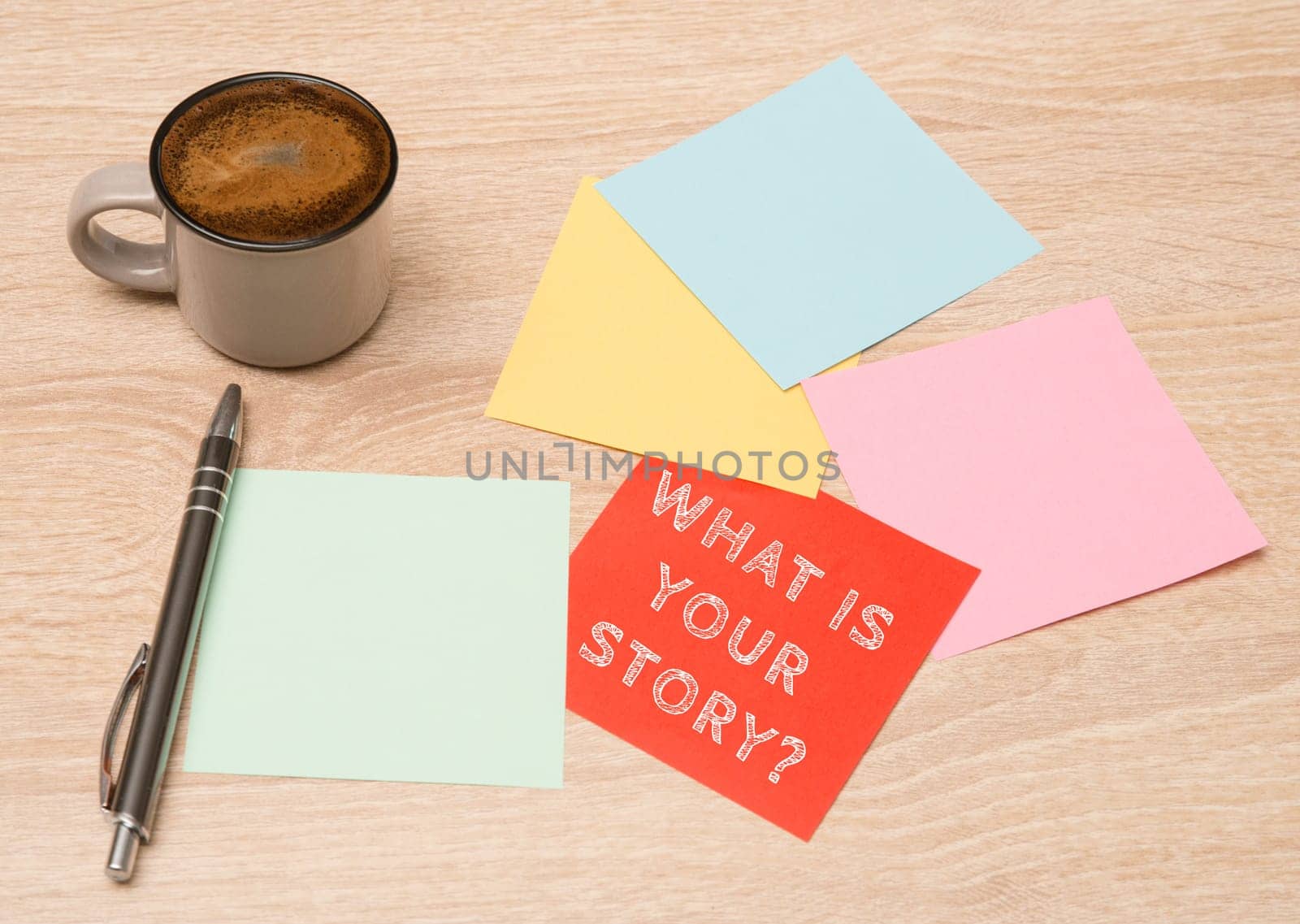 Story telling, cup coffee beside colorful paper, handwritten what is your story, concept business