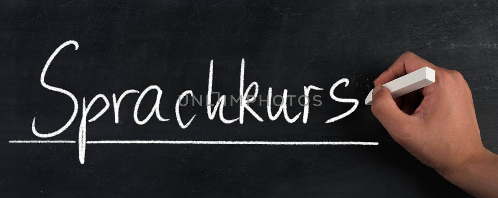 The words language course are standing in the german language on a blackboard