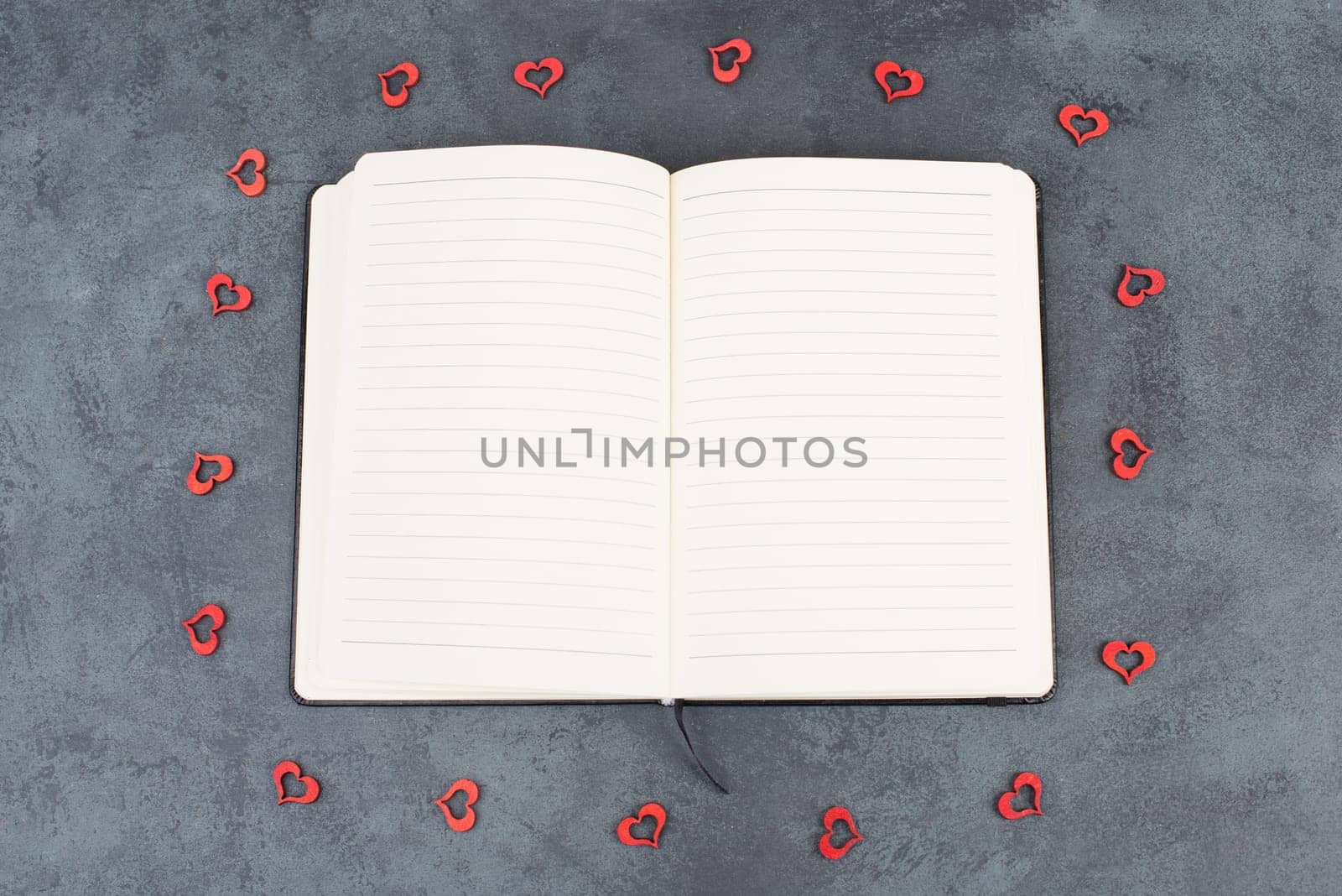 Empty notebook with wooden hearts and a pen