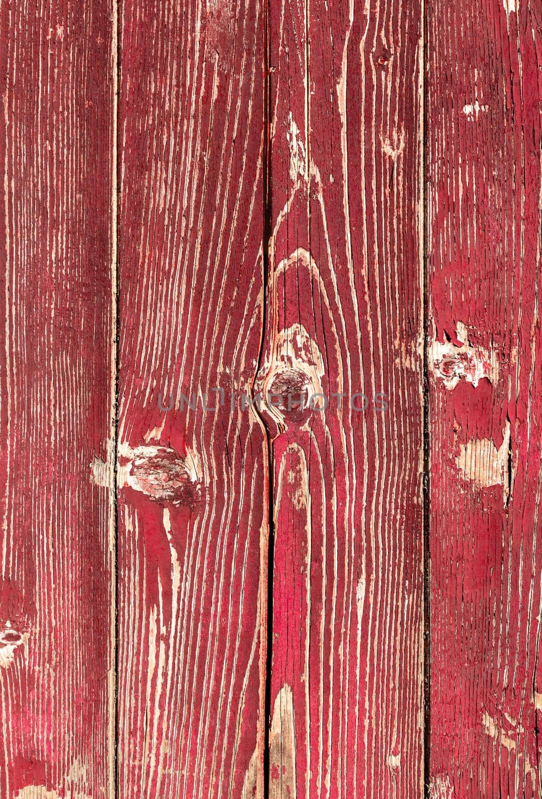 Wooden red planks. Background consisting of wooden planks with peeling red paint.