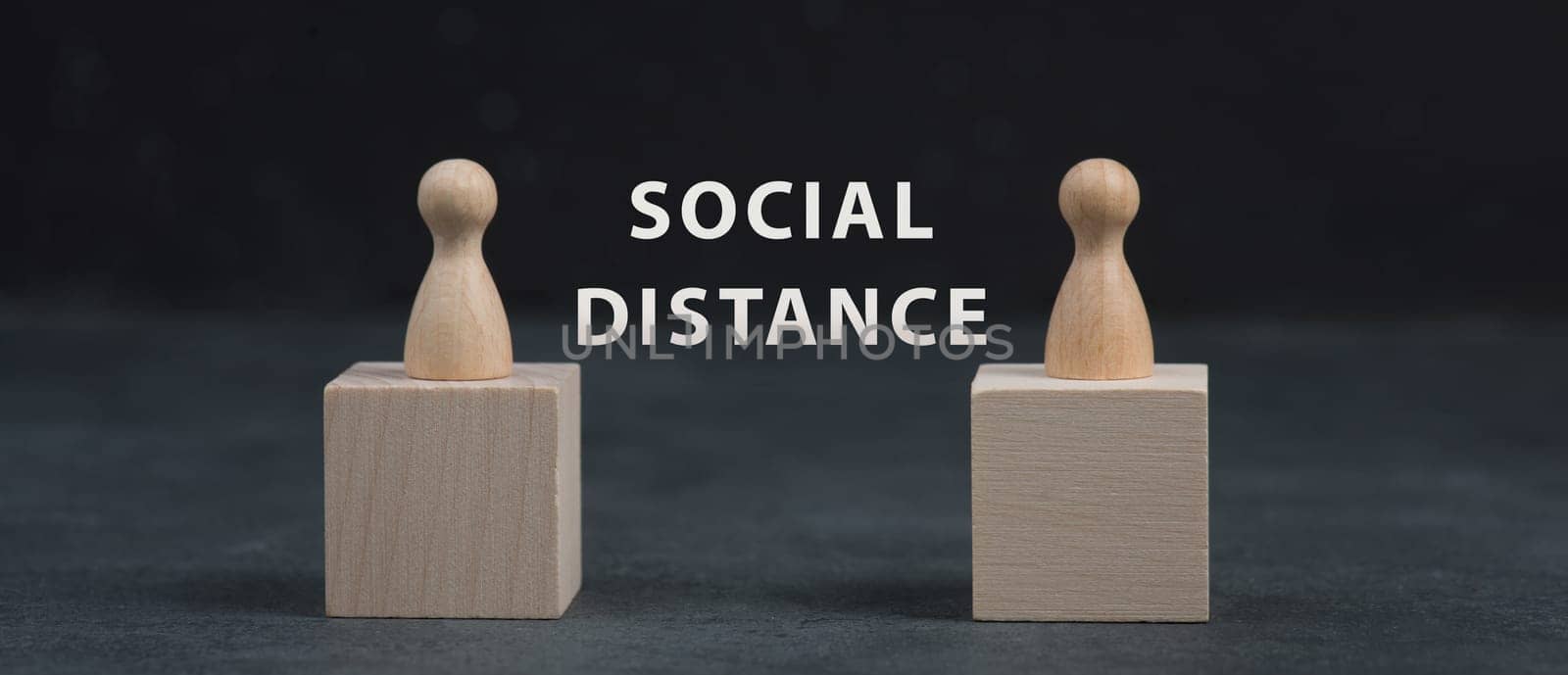 Two woooden people keep social distance, Covid-19 pandemic regulations