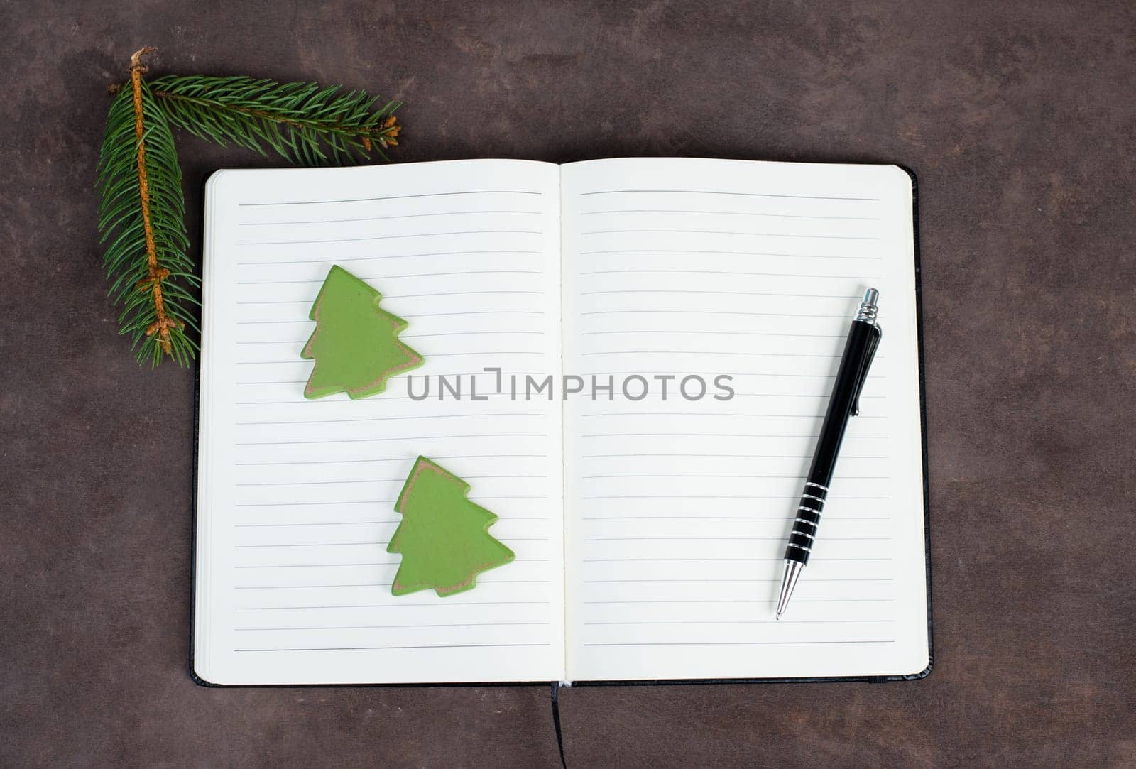 Empty notebook with christmas decoration, wooden trees, branch of fir