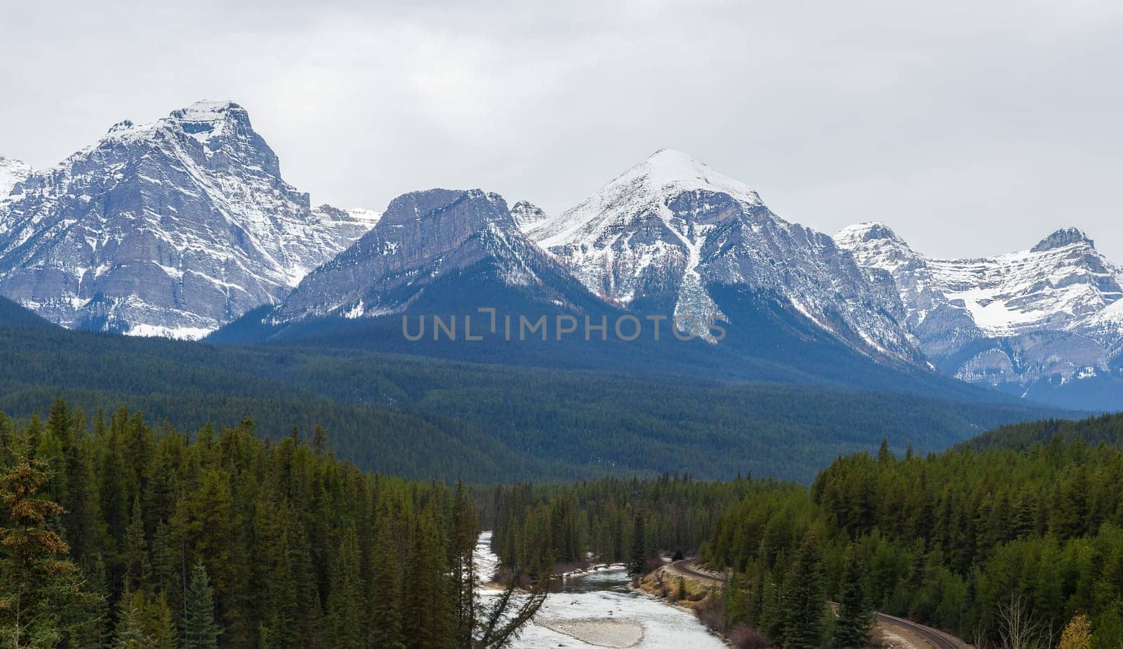 Panorama view Nicholas Morant's Curve on Canadian Pacific Railway with Three Sisters Rocky Mountains in early winter at Morant's Curve in Banff National Park, Alberta, Canada