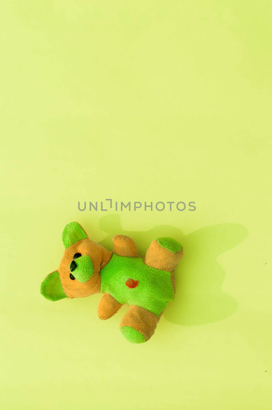 Rabbit teddy bear on yellow color background. Table top view. Vertical. Flat lay. Copy space for text.