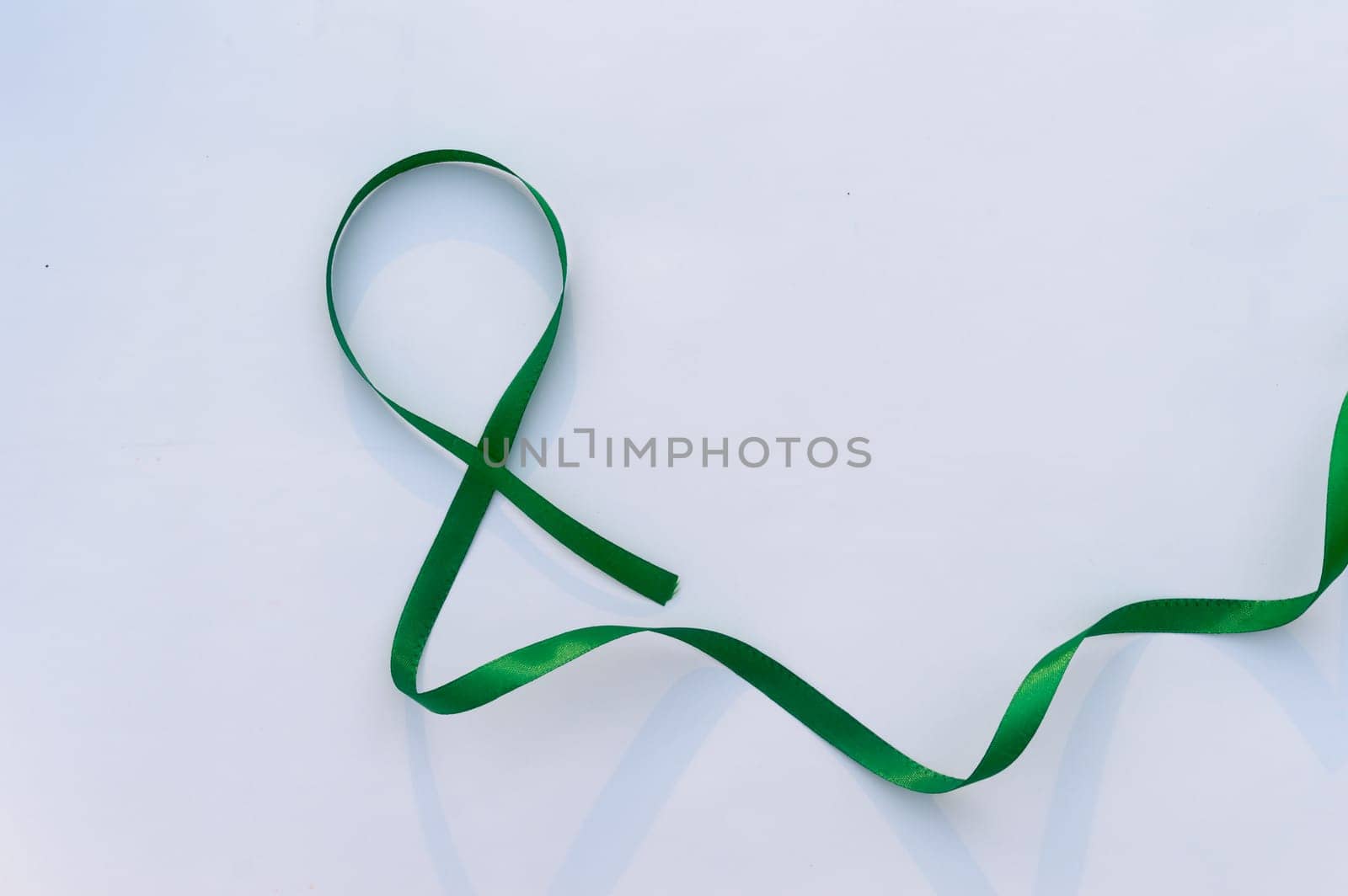 Green Ribbon on white background. Table top view. copy space for text