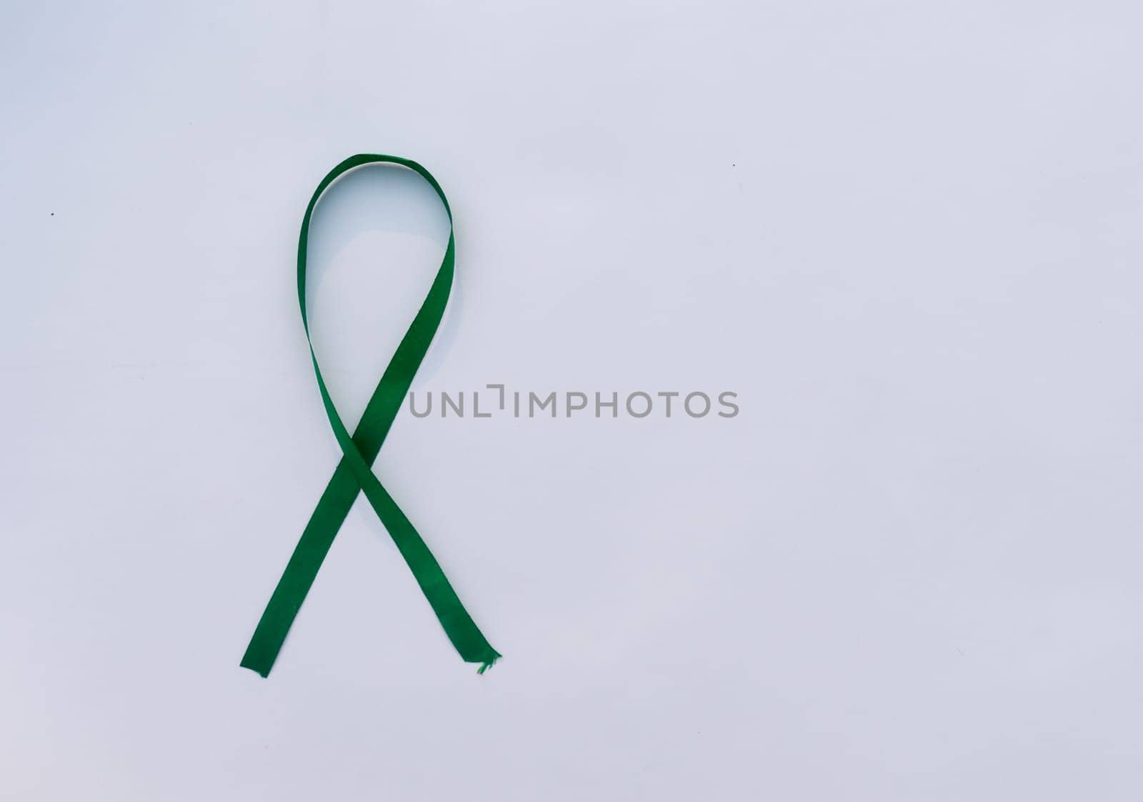 Green Ribbon on white background. Table top view. copy space for text.