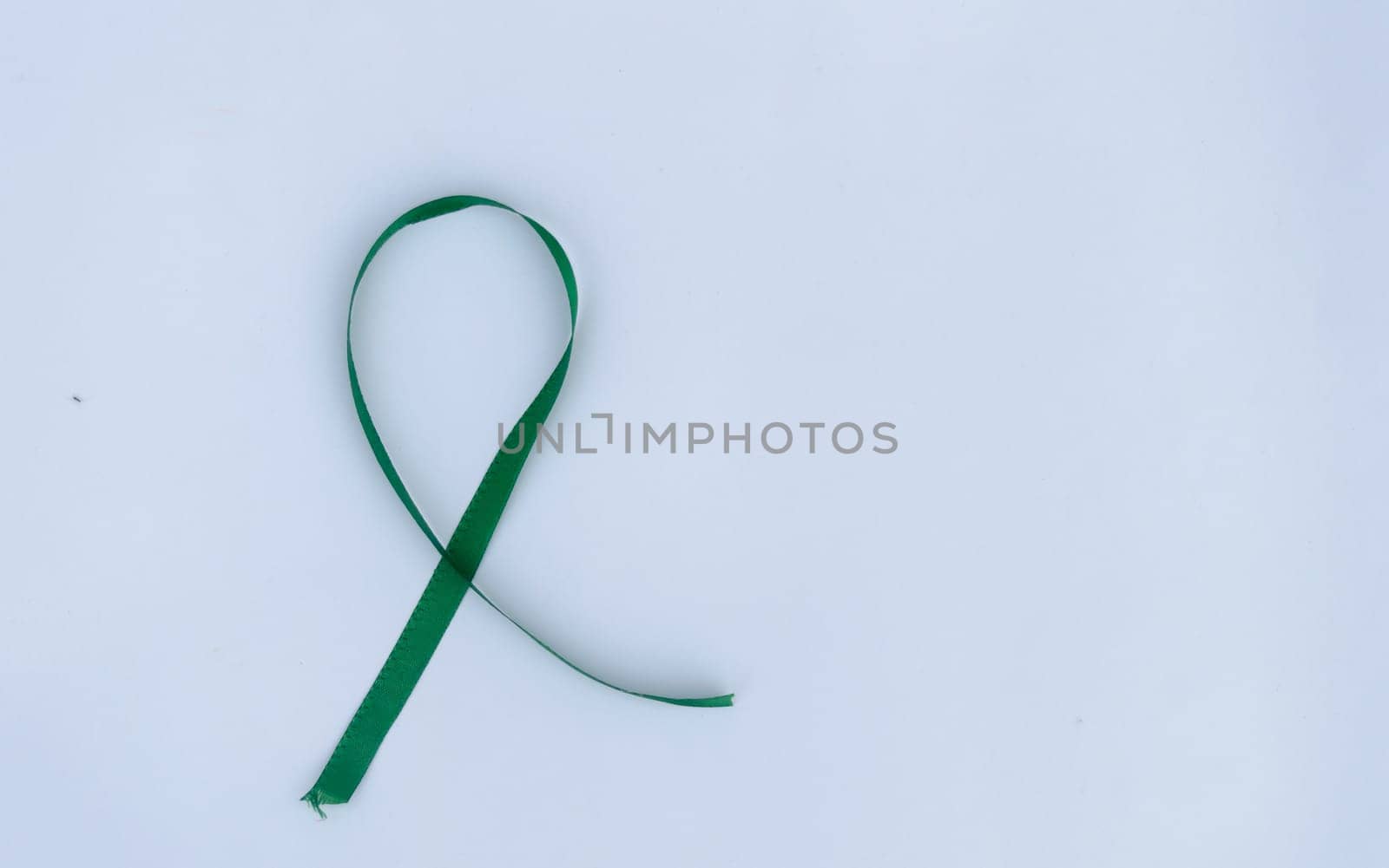Green Awareness Ribbon on white background. Table top view. Health care and medical. Copy space for text.