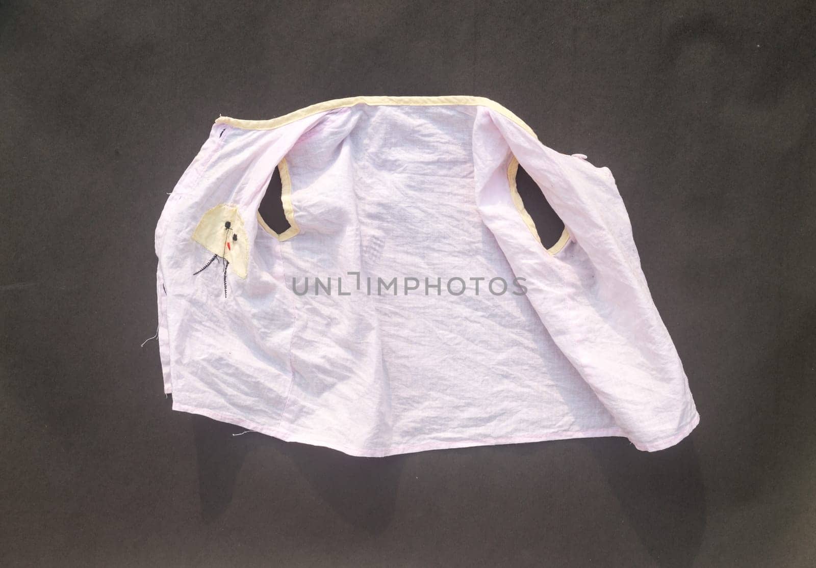 White shrunken baby clothes on floor after laundry washing. Due to laundry the cotton fibers shrink than normal size. Table top view. copy space for text.