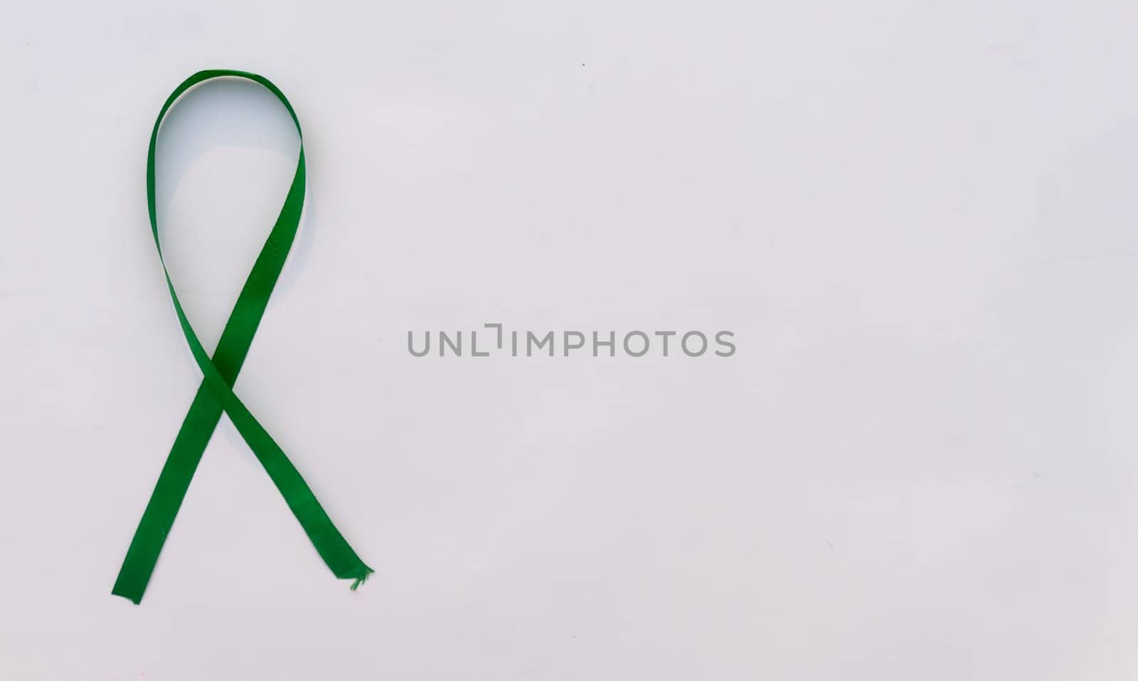 Green Awareness Ribbon on white background. Table top view. Health care and medical. Copy space for text.