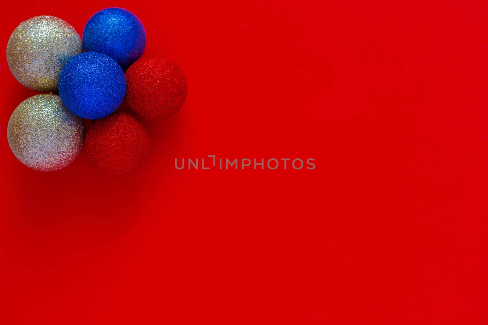 Christmas balls of silver blue and red color are in the shape of a flower on a red background. New Year, the flag of Russia, top view, flat lay, copy space, isolate