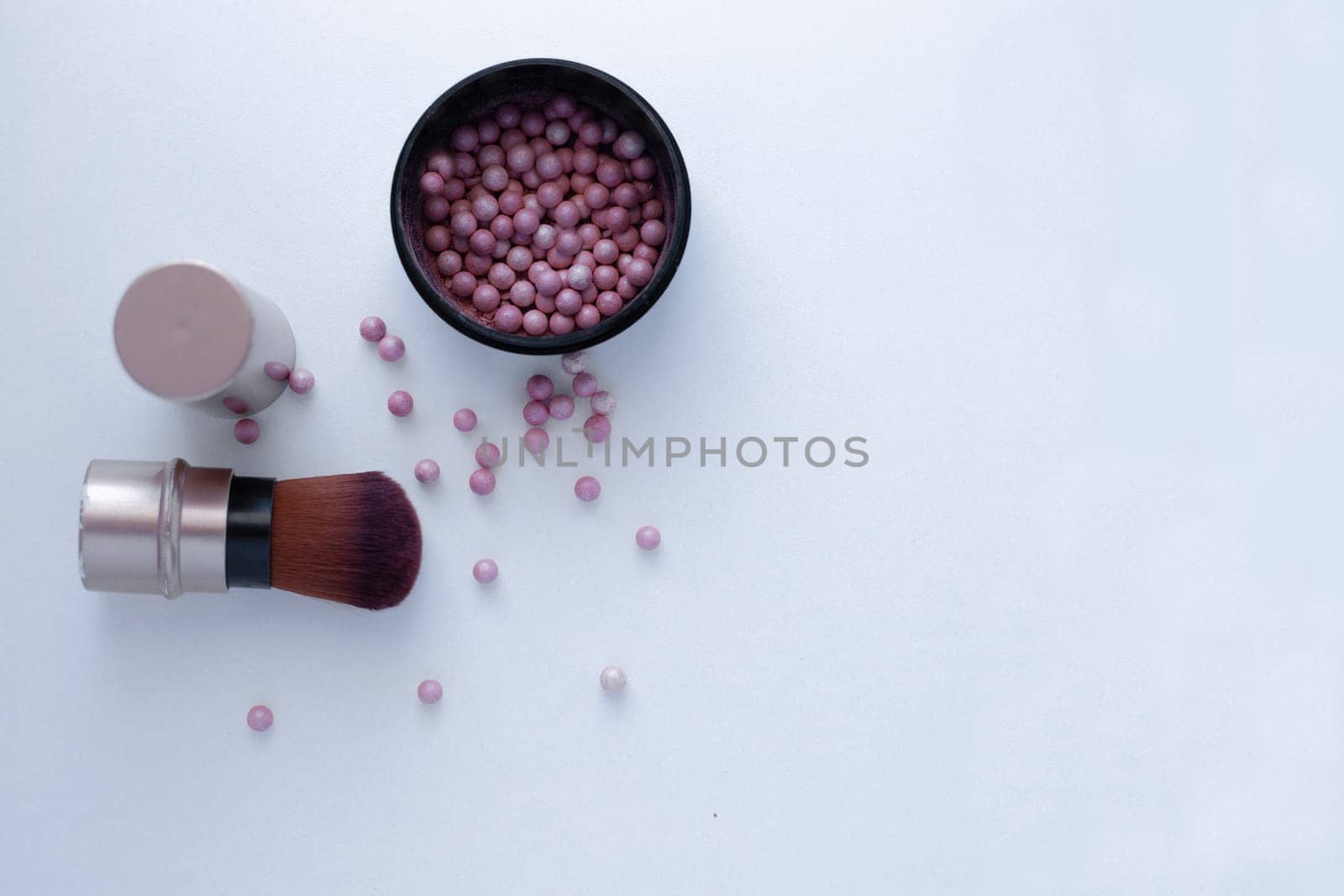 Blush balls of pink and cream color and a brush for applying blush on a white background with a place for text. top view, flat lay, copy space, isolate. High quality photo