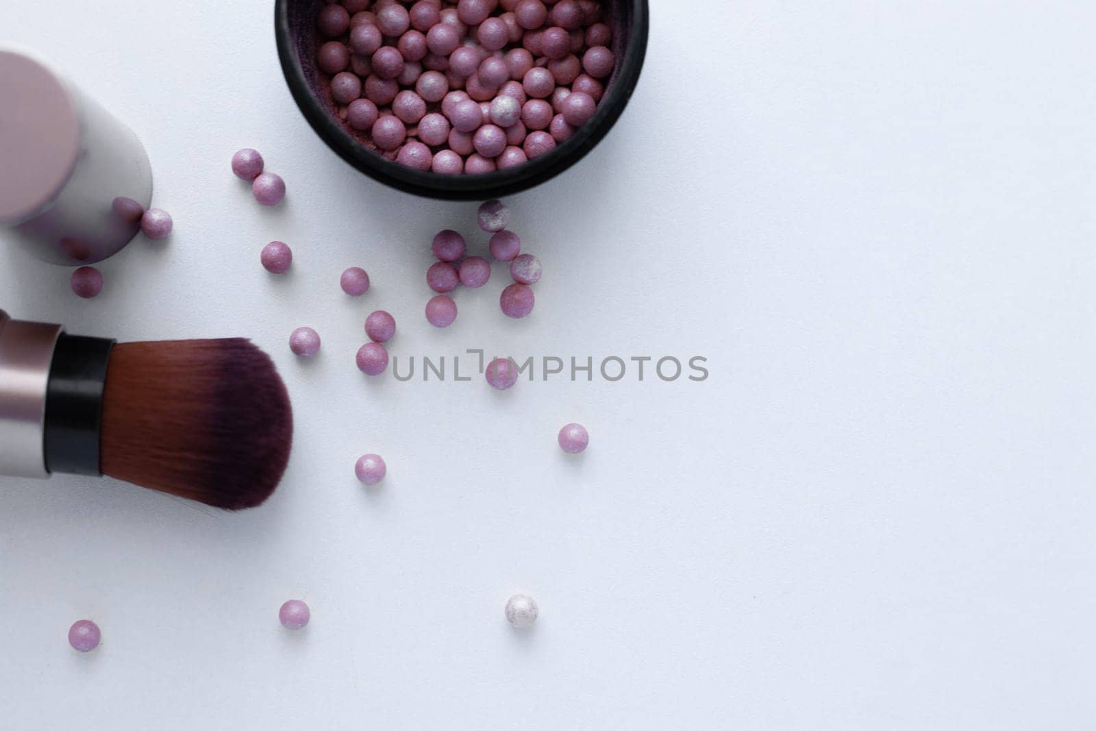 Blush balls of pink and cream color and a brush for applying blush on a white background with a place for text. top view, flat lay, copy space, isolate. High quality photo