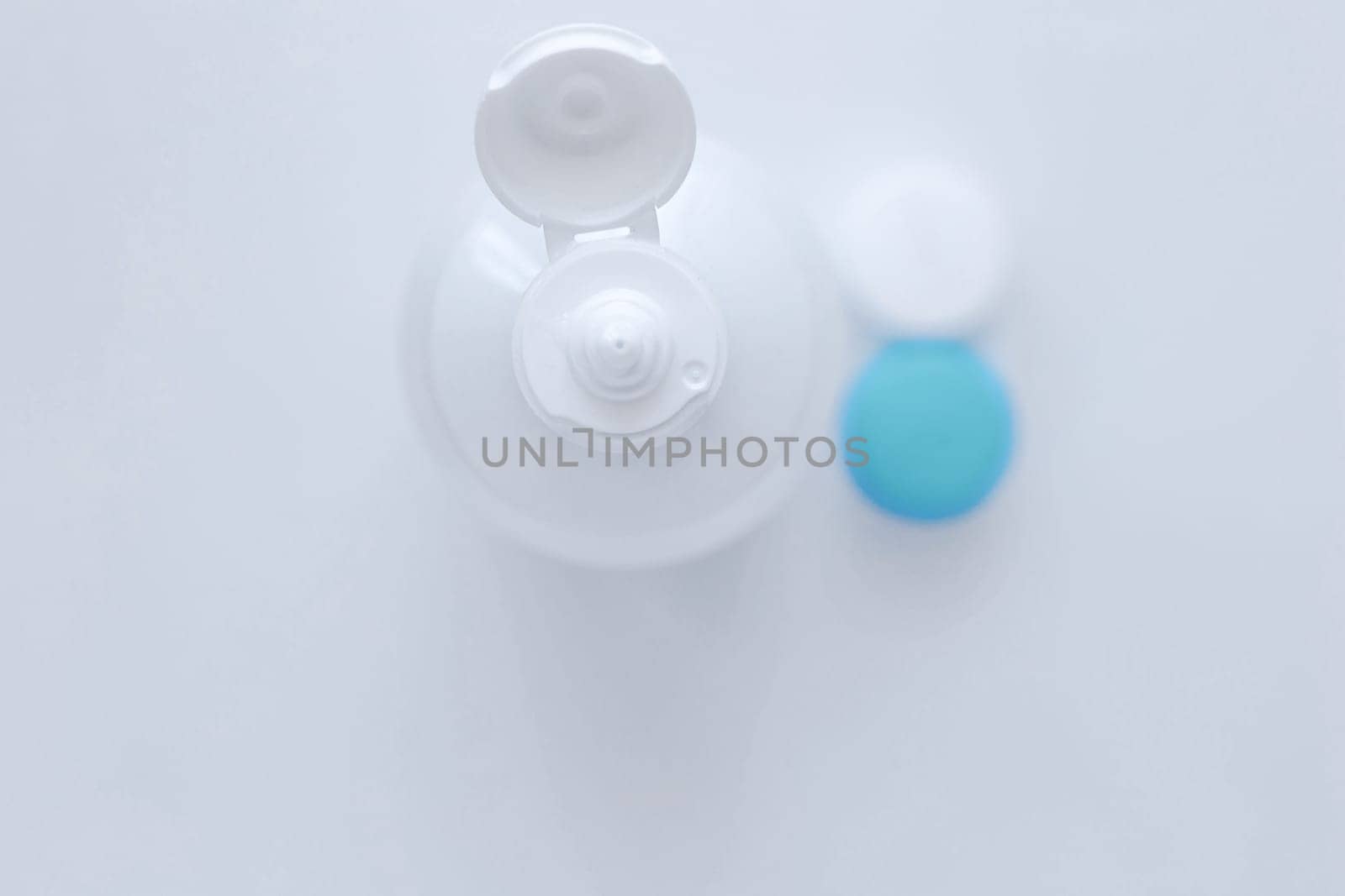 The lens container and the lens storage liquid lie in the center on a white background. top view, flat lay, copy space, isolate. High quality photo