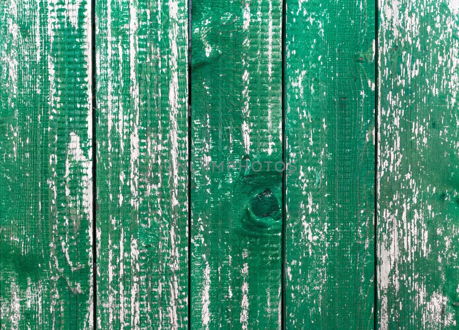 Wooden green planks. Background consisting of wooden planks, with peeling green paint.