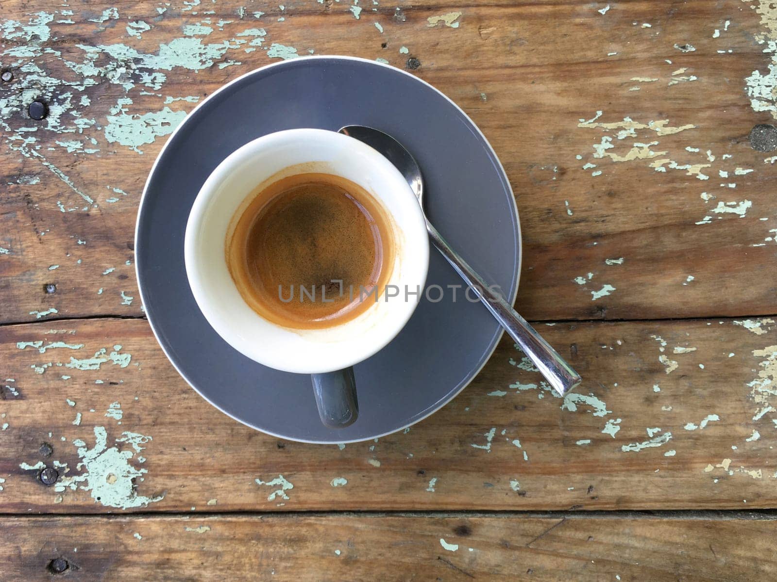 Top view coffee cup with little spoon on wooden table background. Vintage style.