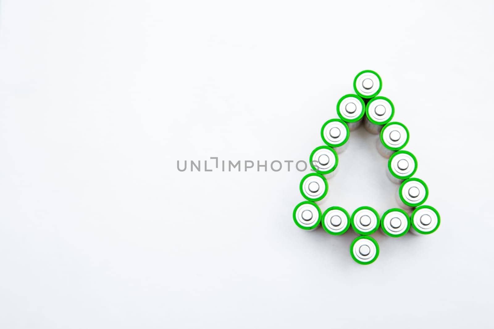 The batteries are in the shape of a Christmas tree on a white background. top view, flat lay, copy space, isolate. High quality photo