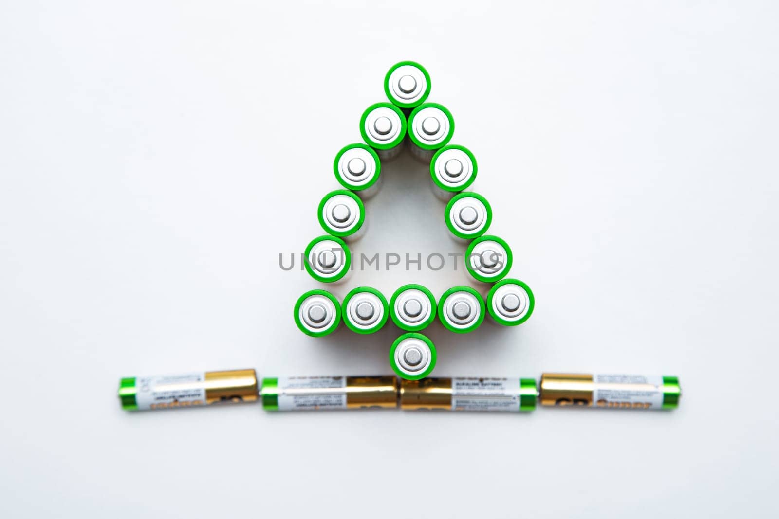 The batteries are in the shape of a Christmas tree on a white background. top view, flat lay, copy space, isolate. High quality photo