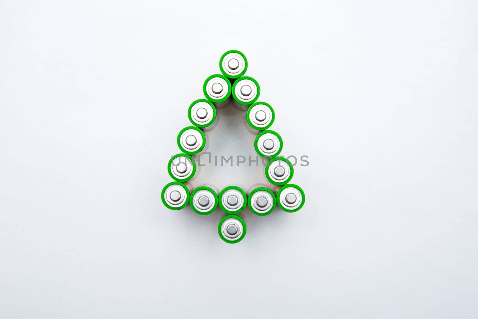 The batteries are in the shape of a Christmas tree on a white background. top view, flat lay, copy space, isolate. High quality photo