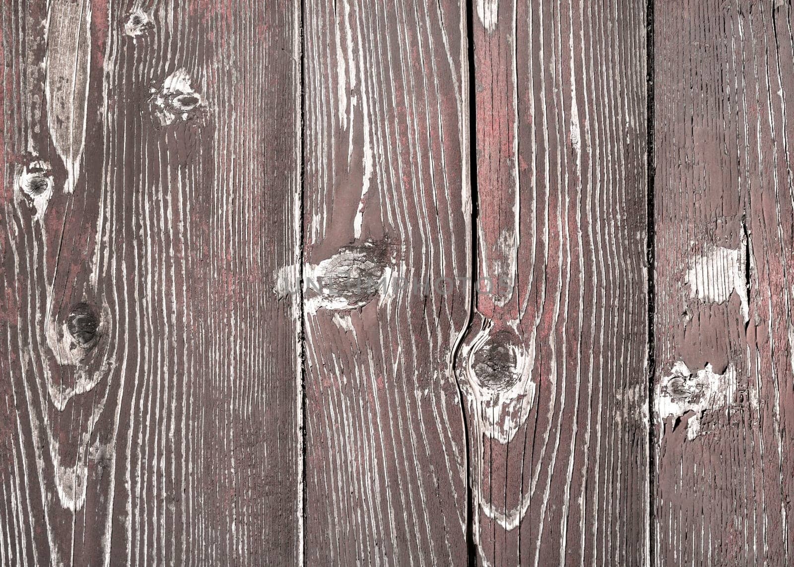 Close-up red wooden background. Old wooden planks with peeling paint cracked by a rustic background.