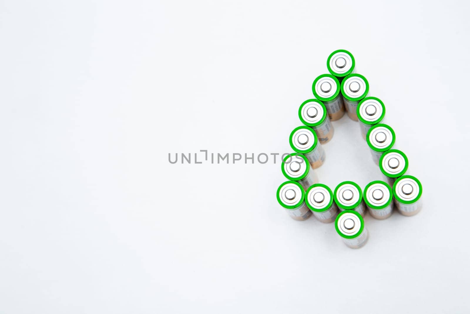 The batteries are in the shape of a Christmas tree on a white background. top view, flat lay, copy space, isolate. High quality photo