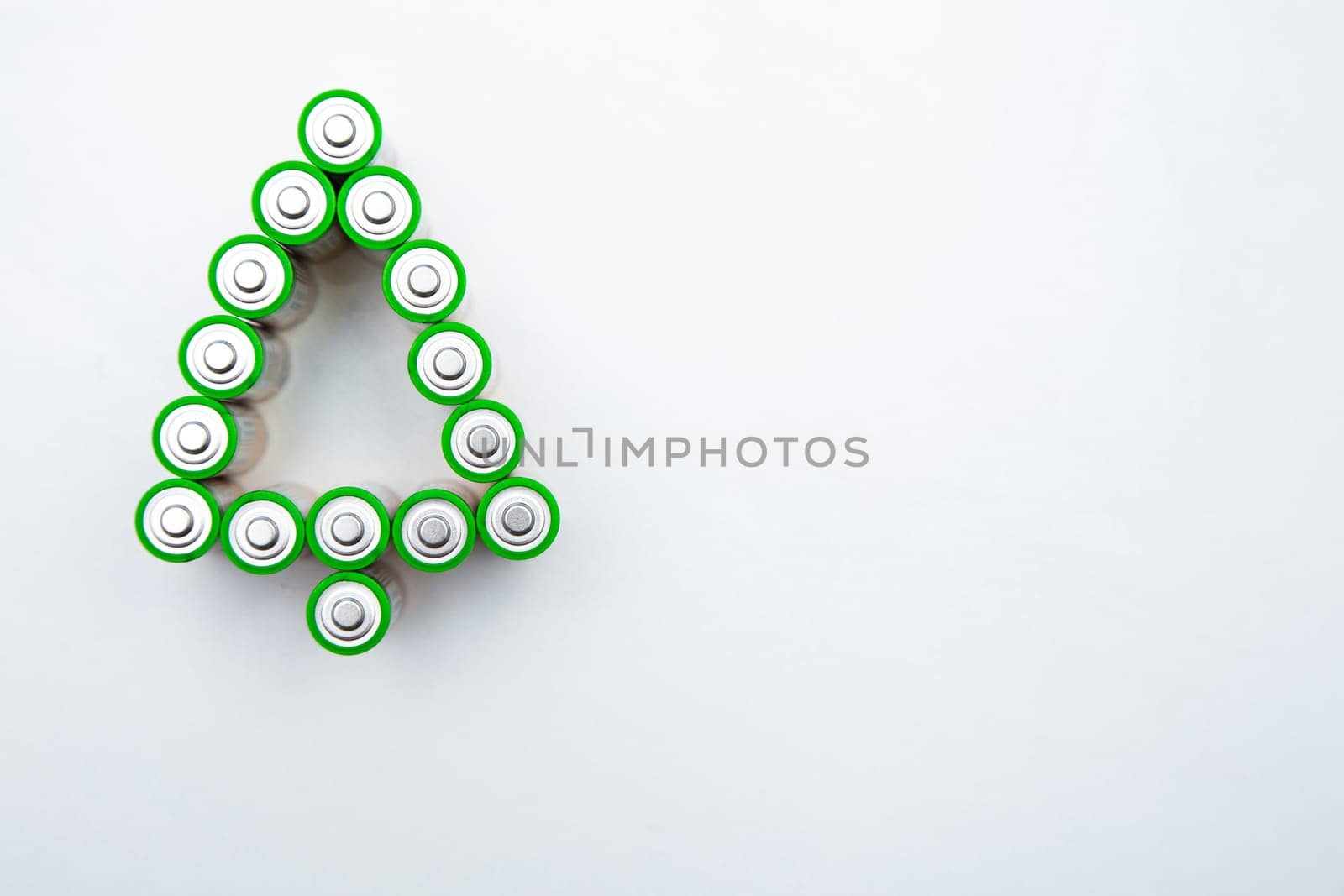 The batteries are in the shape of a Christmas tree on a white background. top view, flat lay, copy space, isolate. High quality photo