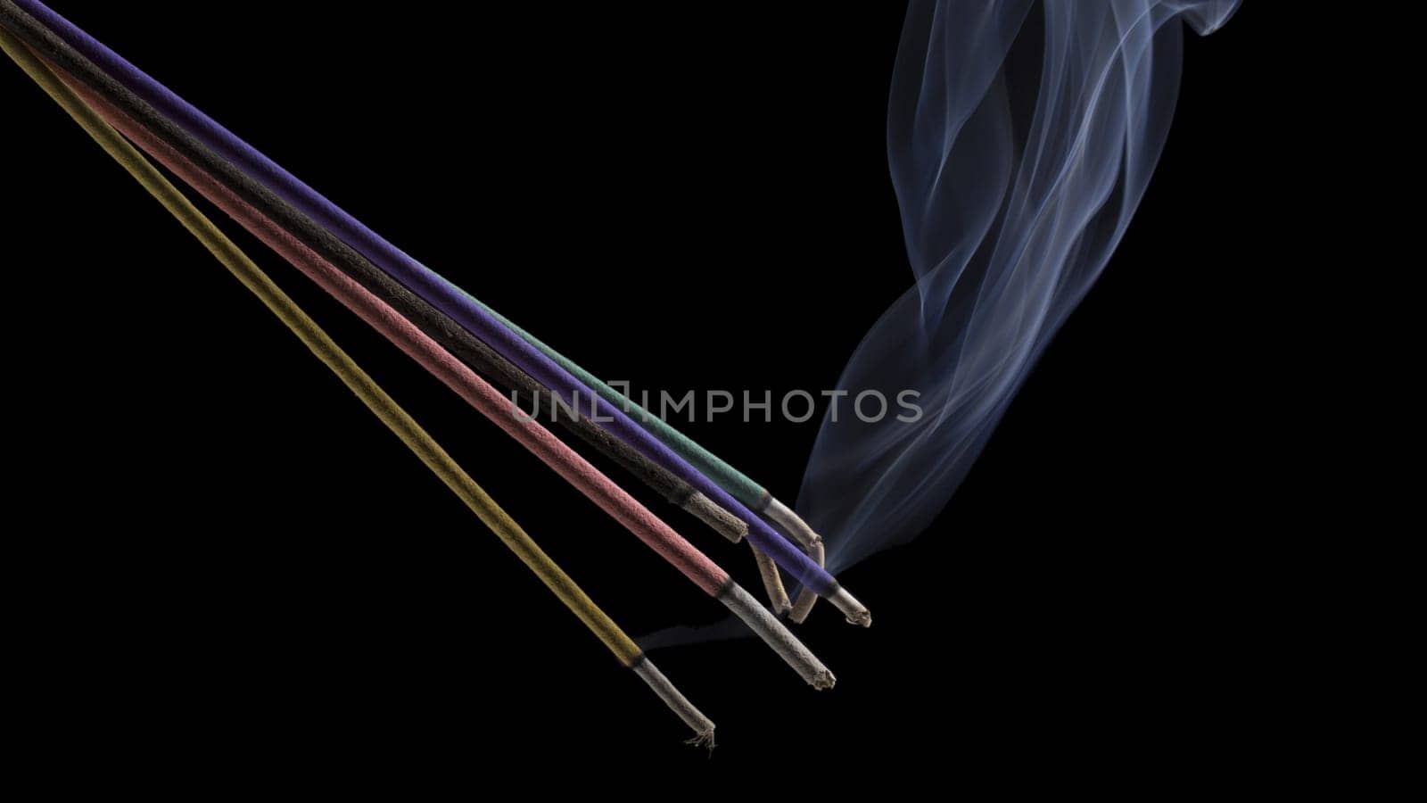 Burning indian or thai incense aroma sticks variety with smoke, isolated on black