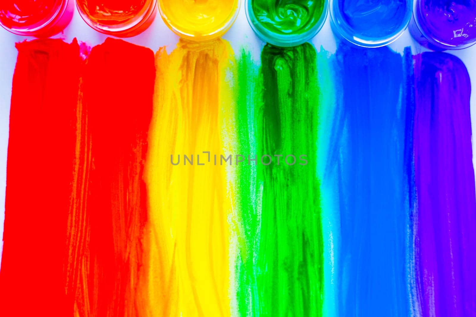 Colorful lines drawn from the paint cans down in the form of a rainbow on a white background. top view, flat lay, copy space, isolate. High quality photo