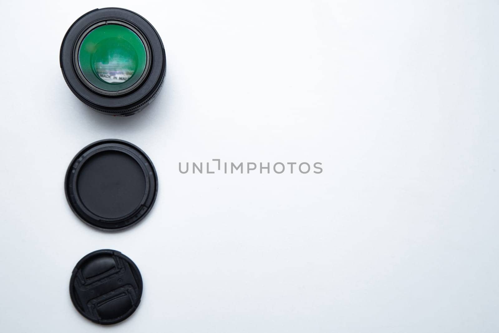 A small fixed lens for a professional camera on a white background with two covers. High quality photo
