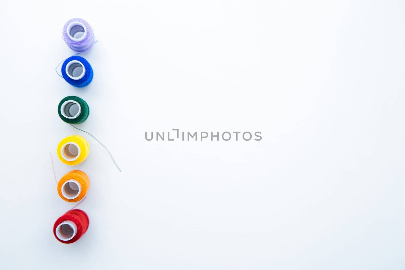Skeins with threads are lined up in a row according to the color of the rainbow. top view, flat lay, copy space, isolate High quality photo