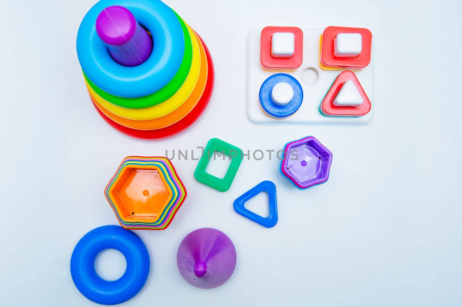 Children's educational toys: a pyramid and sorters lie on a white background with a place for text. top view, flat lay, copy space, isolate. High quality photo