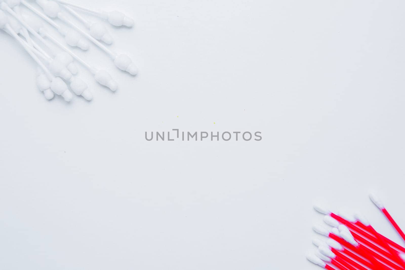 Disposable ear sticks for children and ordinary disposable ear sticks lie on a white background opposite each other. top view, flat lay, copy space, isolate. High quality photo