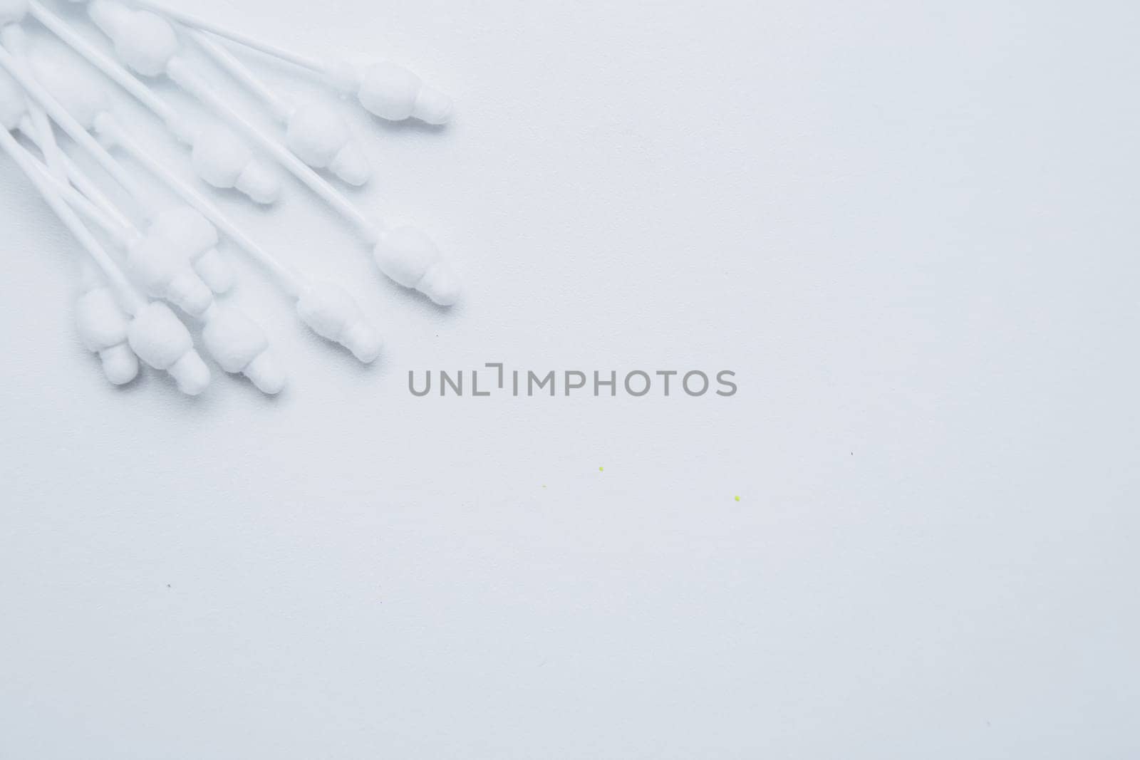 Disposable ear sticks for children are lying on a white background in the upper corner. top view, flat lay, copy space, isolate. High quality photo