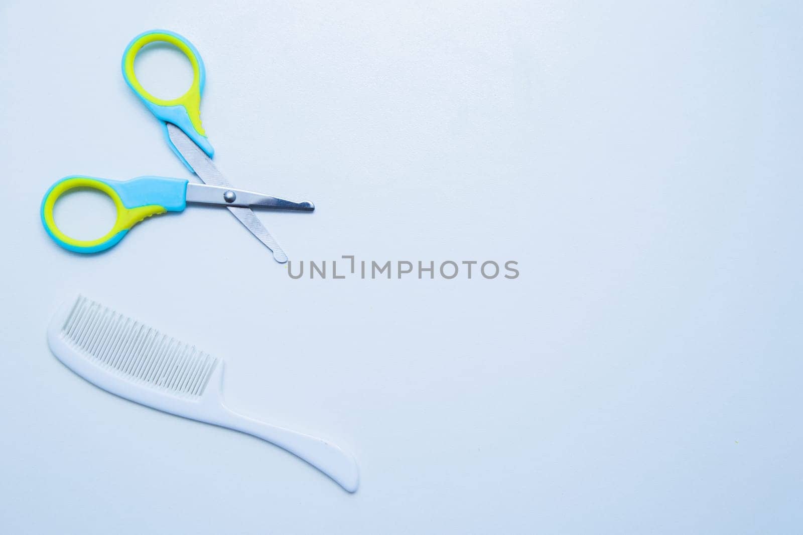 Children's scissors for cutting nails and a children's comb are on a white background. top view, flat lay, copy space, isolate. High quality photo