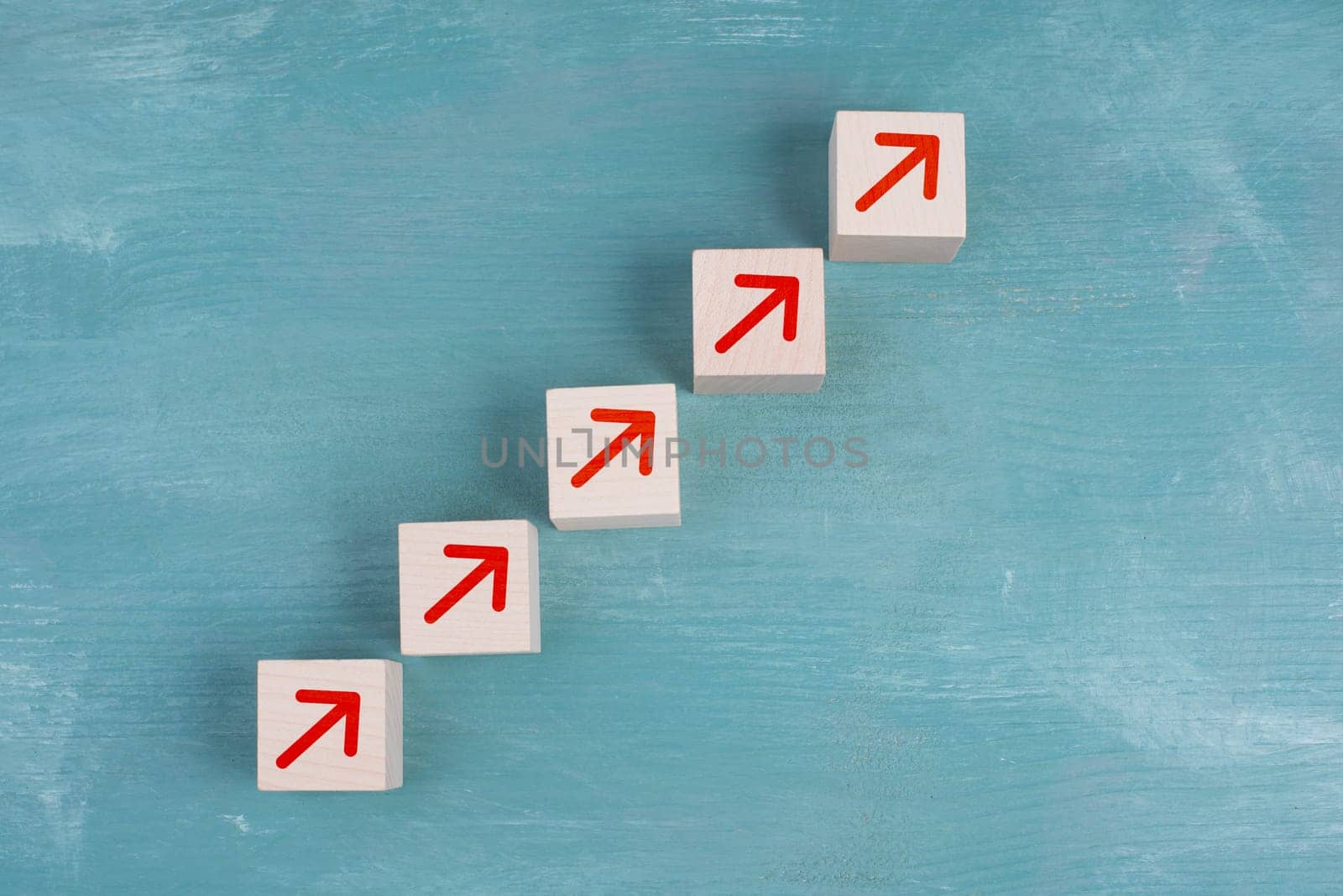 Red arrows going up on wooden cubes, blue background