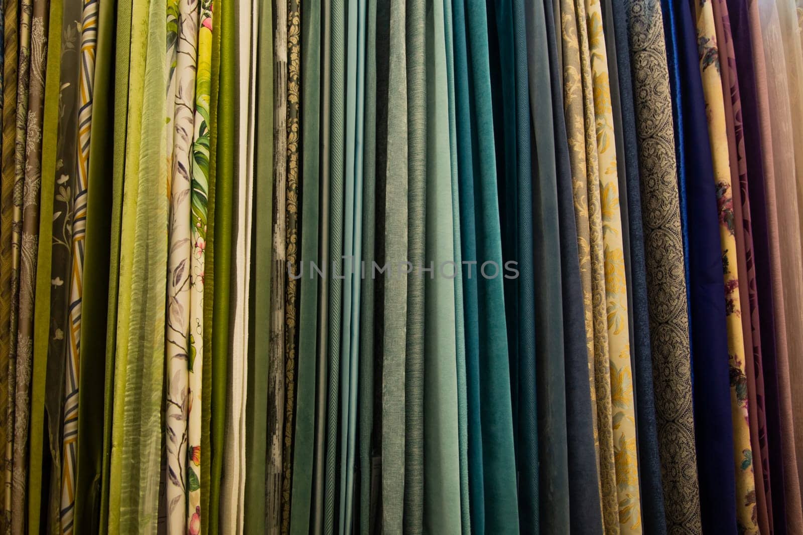 Curtains of different colors and patterns for the room hang horizontally. High quality photo