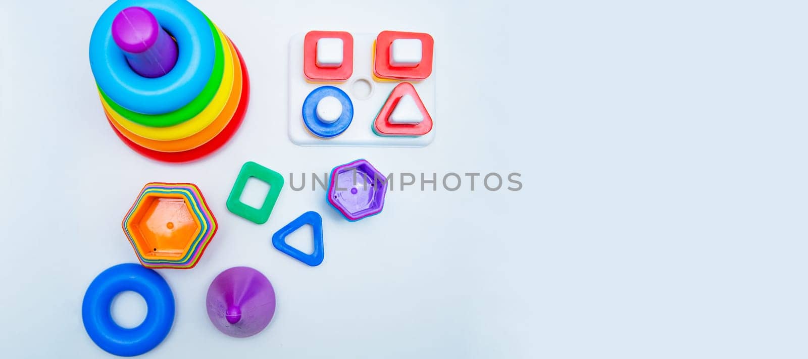 Children's educational toys: a pyramid and sorters lie on a white background with a place for text. top view, flat lay, copy space, isolate. High quality photo