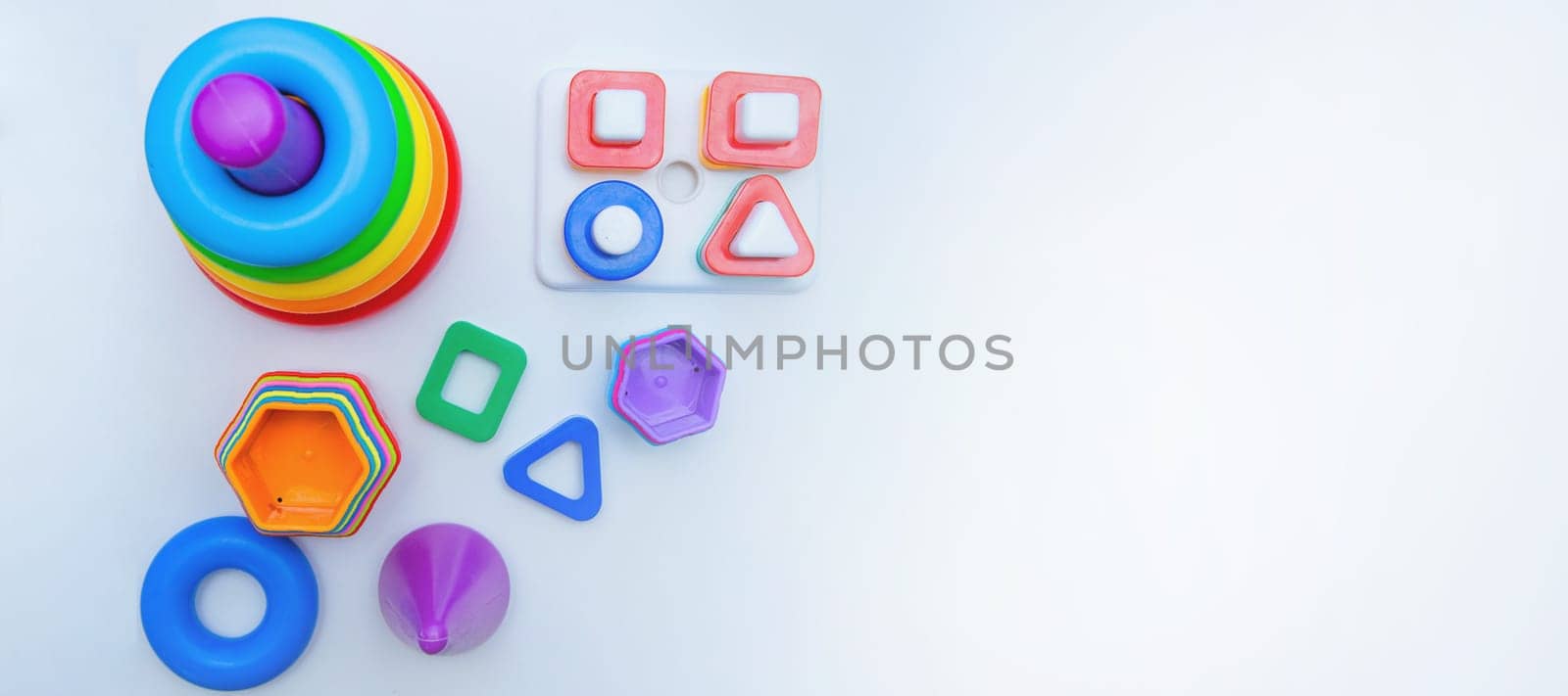 Children's educational toys: a pyramid and sorters lie on a white background with a place for text. top view, flat lay, copy space, isolate. High quality photo