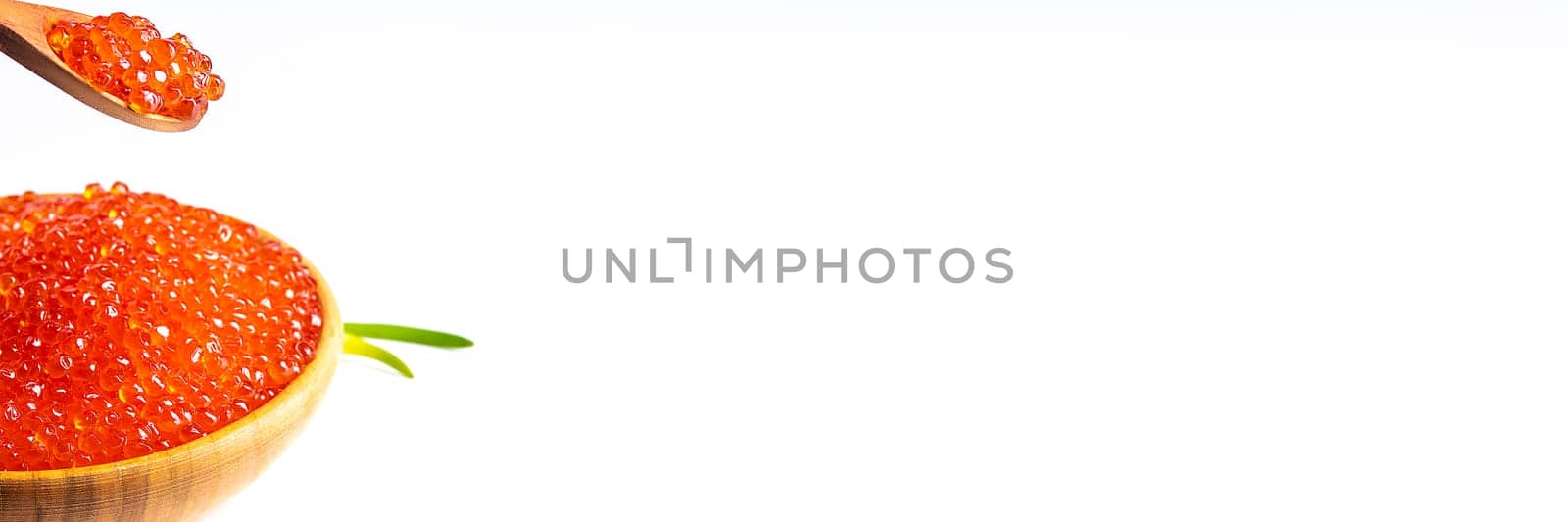 Red caviar in a wooden cup on a white background with a spoon and green onions. A large pile of bright caviar. Fresh delicious caviar. Isolated. A place for advertising, logo, label, layout, mockup. Layout, template.