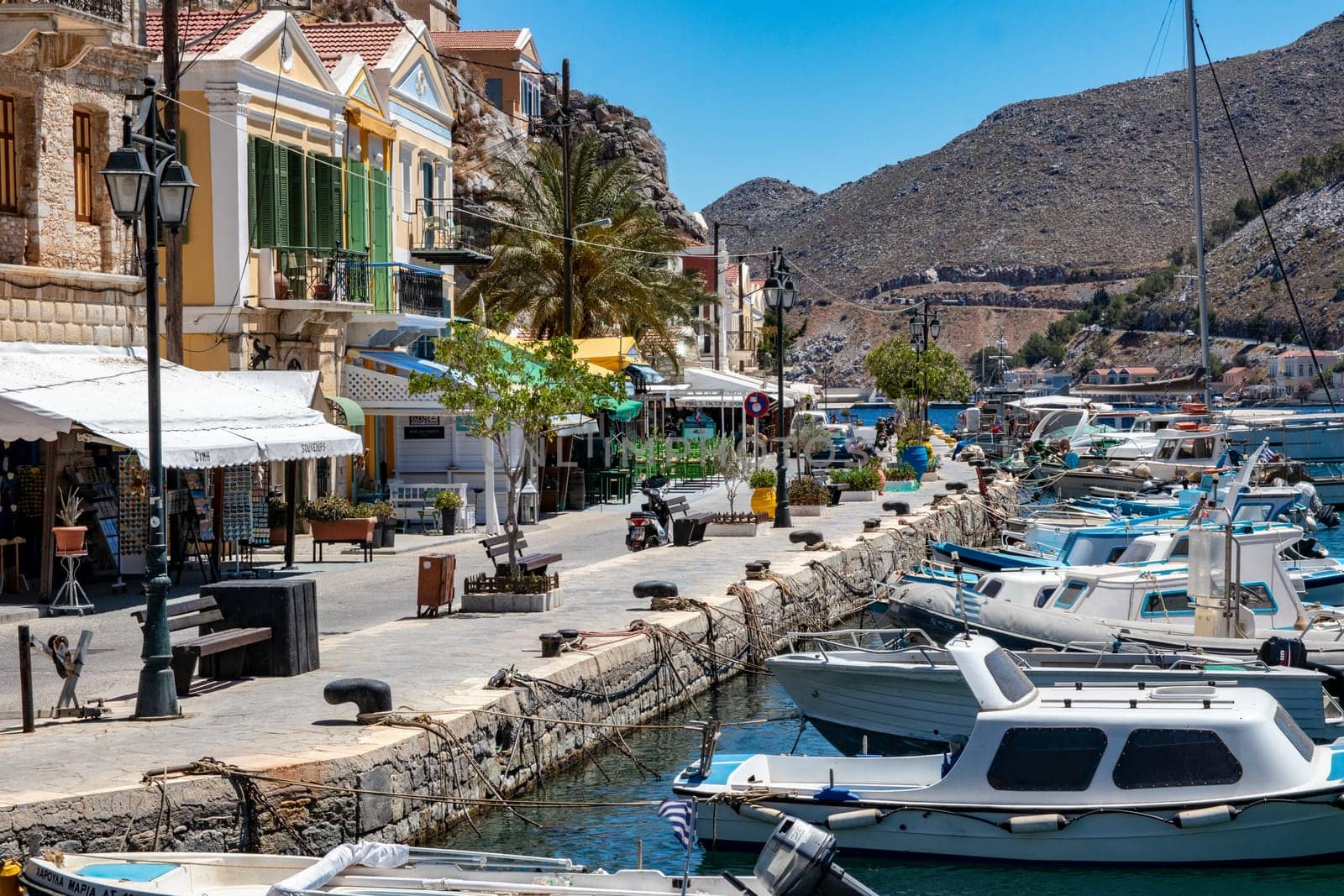 SYMI, Greece - JUN 03, 2021. The harbour of Symi town with the districts of Chorio and Gialos is one of the most beautiful and romantic in the whole Aegean. Colourful mansions stretch up the steep slopes.