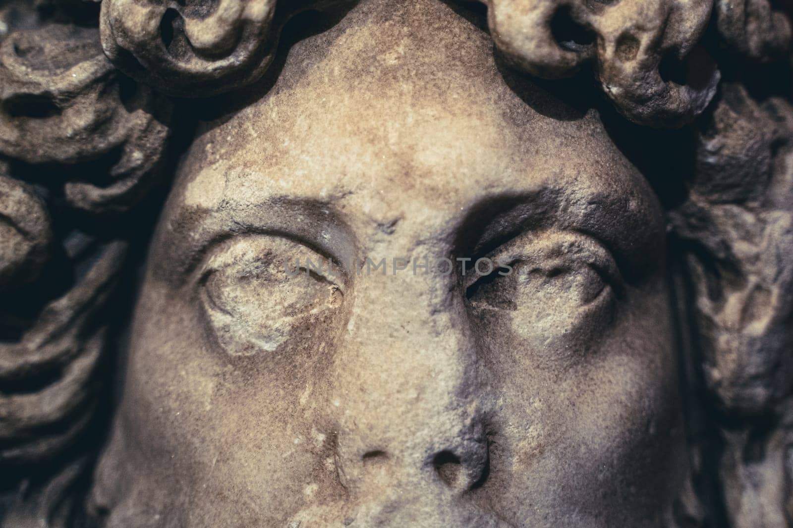 front view closeup of woman antique white marble statue with damaged eyes