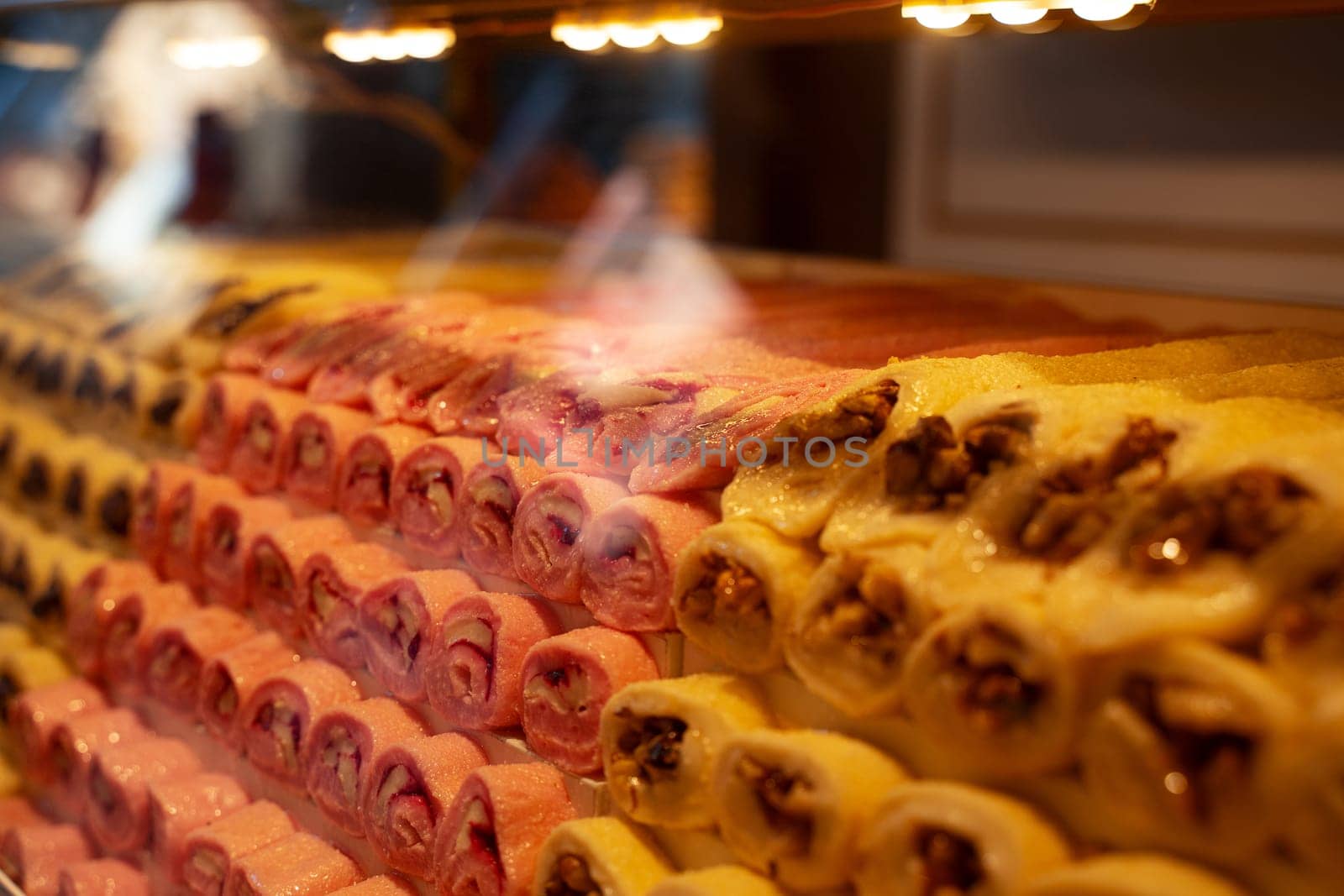 rows of Turkish delight sweets desserts with dried fruits arranged in a pyramid shape and lined up in the store window