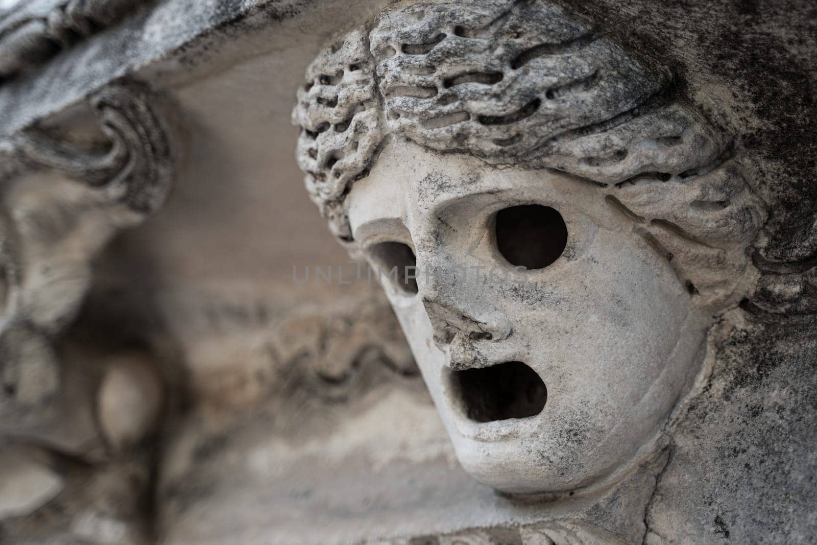 closeup perspective view of stone carved caryatid female figure on postament of ancient Greek temple