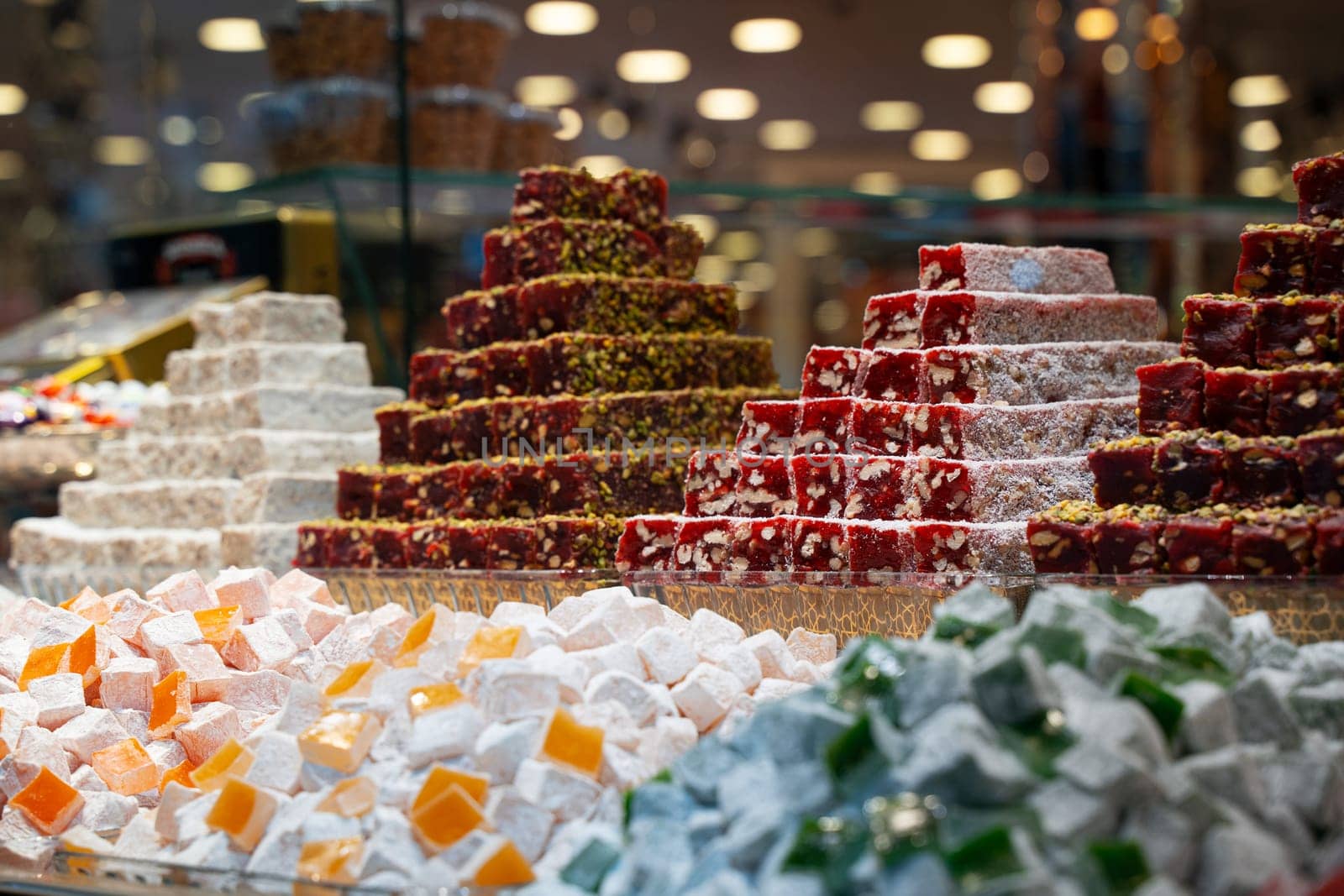 rows of Turkish delight sweets desserts assorted with dried fruits arranged in a pyramid shape and lined up in the store window