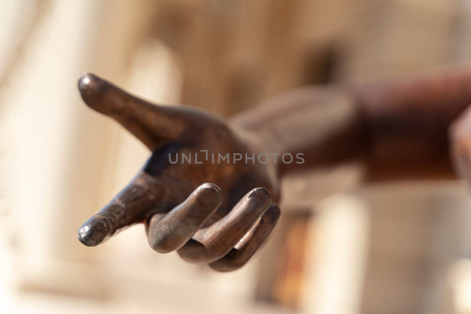 closeup detail of bronze statue hand reaching out with the index finger