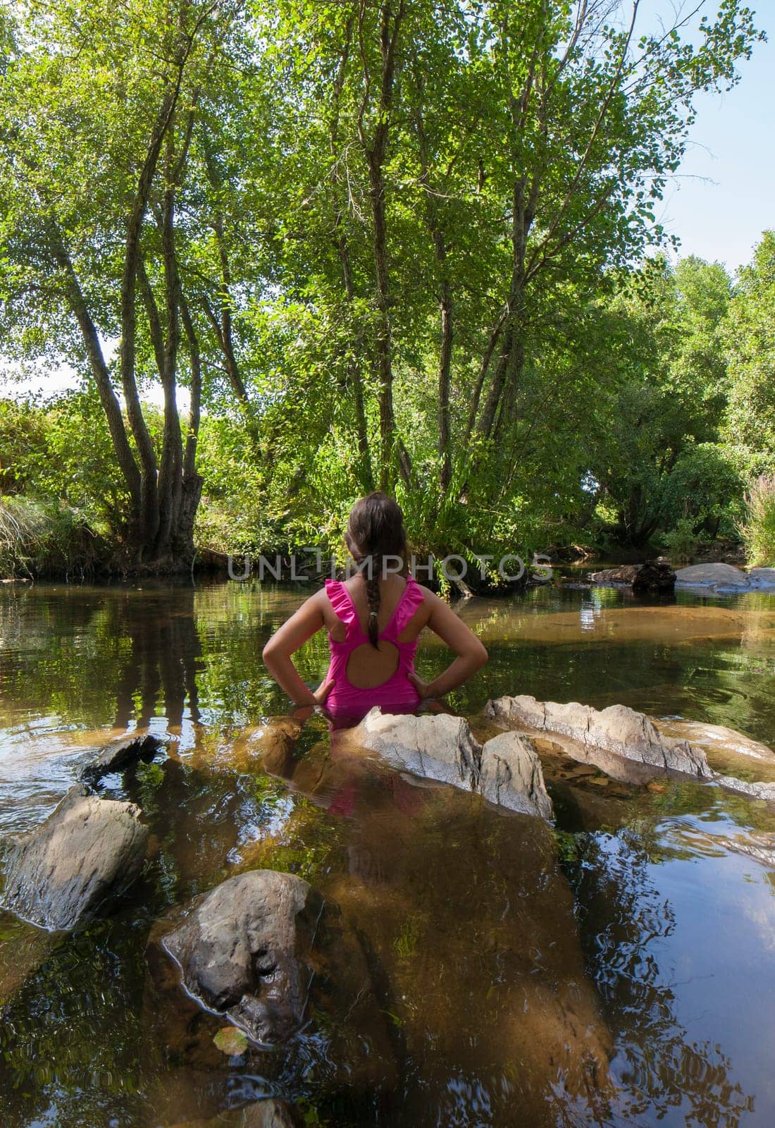 Child girl discovering Gevora river, La Codosera, Badajoz, Extremadura, Spain. Idyllic location of crystal clear waters and riverside forests